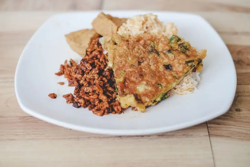طبق أرز بني مع تمبيه مفتت وقرص تمبيه ذهبي